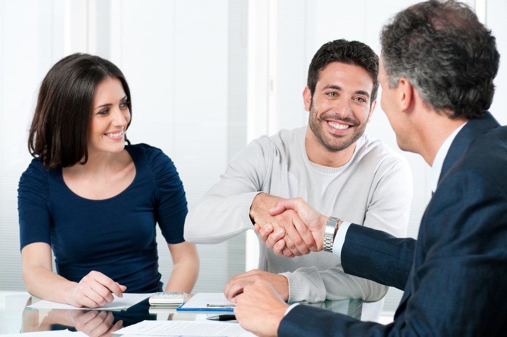 Happy,Couple,Seal,A,Deal,With,Their,Personal,Financial,Advisor